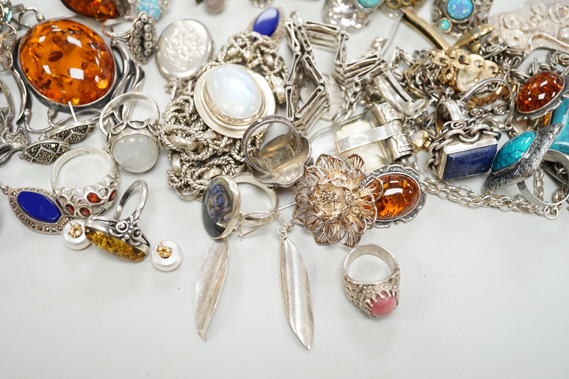 A quantity of 925 and white metal jewellery including amber set brooch, Art Nouveau style brooch and assorted dress rings.